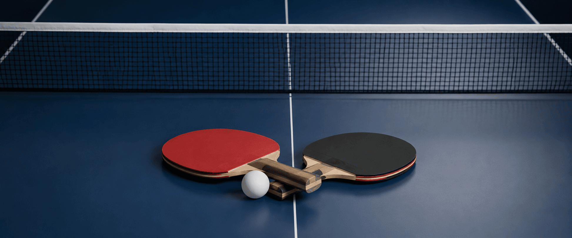 Deux raquettes de tennis de table sur une table bleue